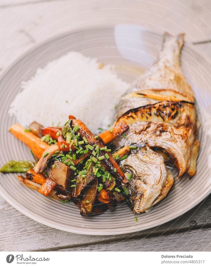 Ein exquisites Gericht aus gebackener Seebrasse mit weißem Reis Kalorien gekocht Essen zubereiten Küche frittiert lecker Diät Abendessen Speise Filet Fisch