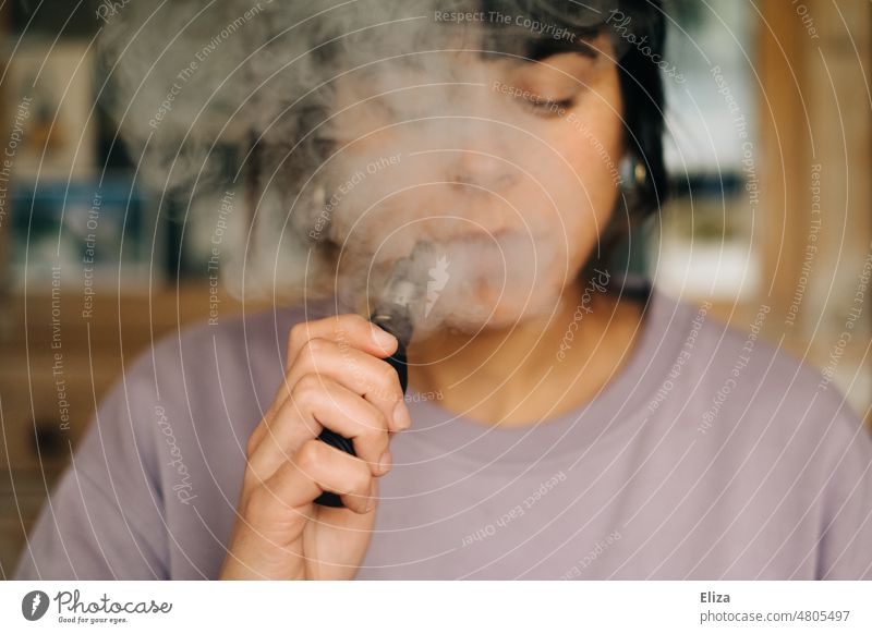 Frau dampft eine E-Zigarette, als Alternative zum Rauchen dampfen Verdampfer Vaping Rauchentwöhnung Raucherin Nikotin elektrisch Dampf elektronische Zigarette