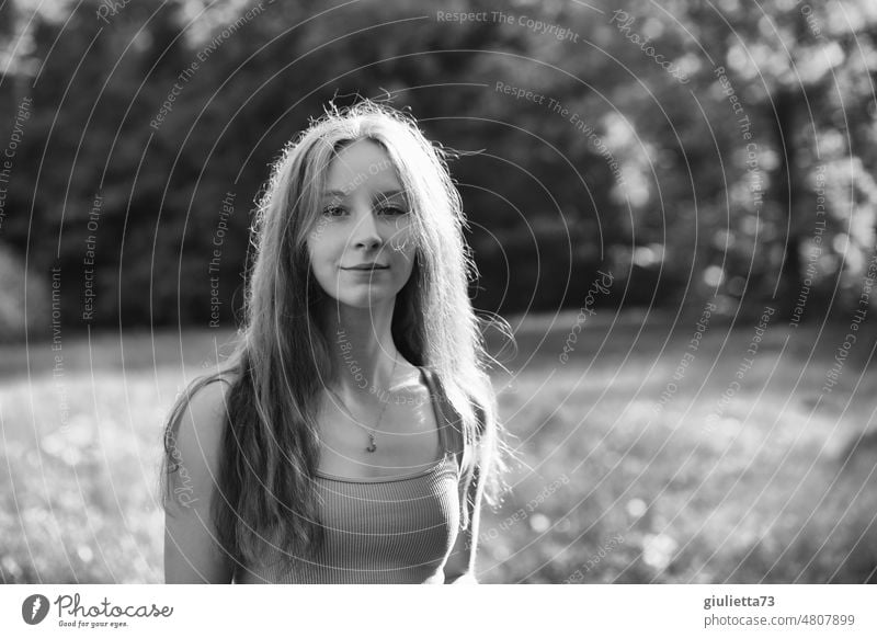 Sommerliches schwarz-weiß-Porträt eines langhaarigen Teenager Mädchens im Park Schwarzweißfoto Nachmittagssonne Junge Frau Jugendliche Außenaufnahme