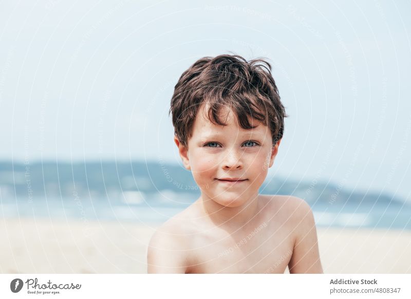 Junge schaut in die Kamera am Strand ruhen Wochenende Sommer Urlaub Lächeln Porträt Resort Kind tagsüber niedlich Kindheit Ufer sich[Akk] entspannen bezaubernd