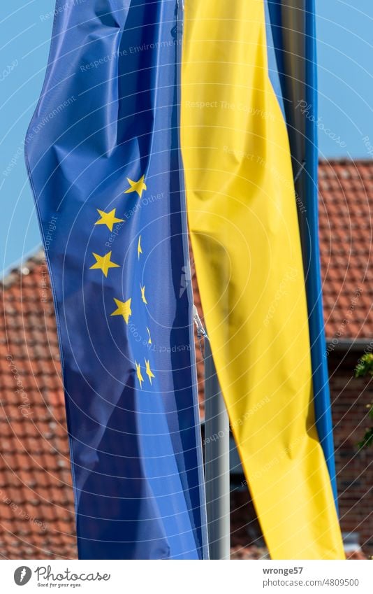 Die Europaflagge und die ukrainische Flagge wehen nebeneinander am Fahnenmast Ukraine Politik & Staat blau blaugelb flattern Flaggenmast Fahnenträger hängen