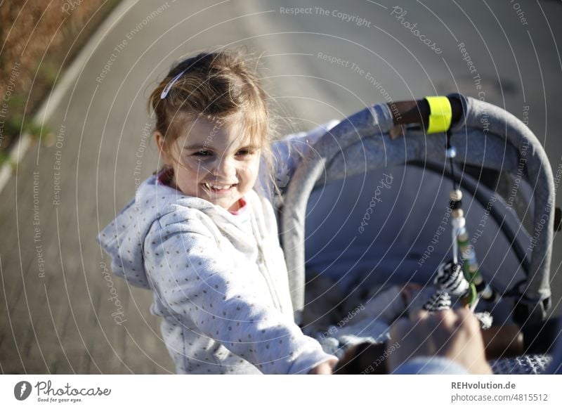 Kind am Kinderwagen Kindheit Lebensfreude Glück authentisch Spielen natürlich Mensch Freizeit & Hobby aktiv Kindheitserinnerung Gefühle Oberkörper Leichtigkeit