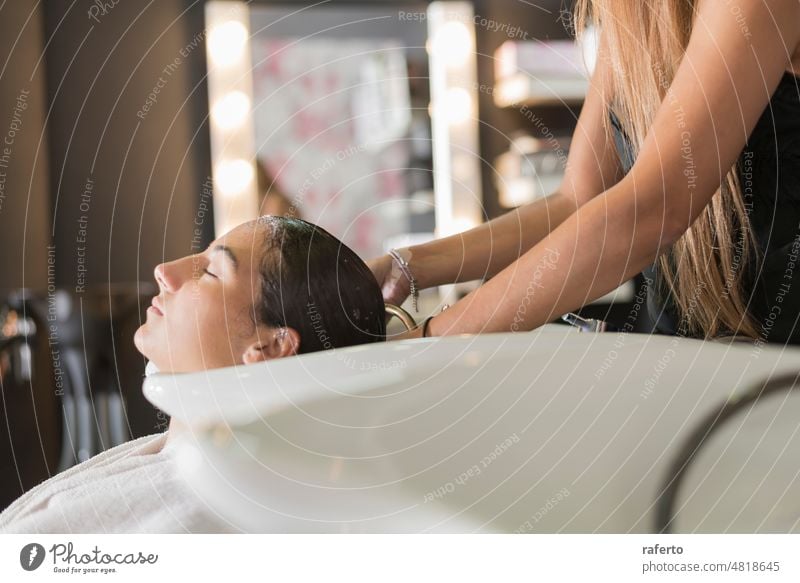 Seitenansicht eines Friseurs, der einem schönen Mädchen im Friseursalon die Haare wäscht. Frau Behaarung Person Klient Schönheit Salon Kopf professionell
