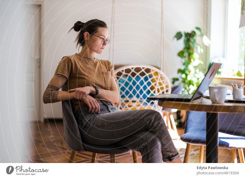 Junge Frau benutzt einen Laptop zu Hause häusliches Leben Selbstvertrauen im Innenbereich heimwärts Menschen jung Erwachsener lässig Kaukasier attraktiv schön