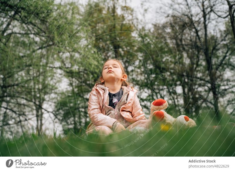 Nettes kleines Mädchen mit Teddybär ruht auf Gras mit geschlossenen Augen Augen geschlossen sich[Akk] entspannen Rasen Natur Spielzeug Kind Park Kindheit Bär