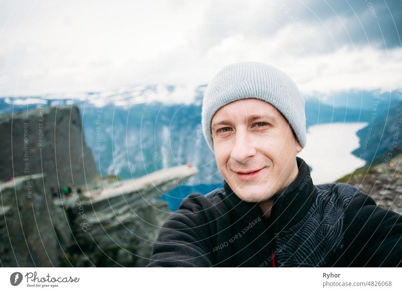 Junger Tourist macht Selfie vor der Kulisse der norwegischen Berge Trolltunga - Trollzunge Abenteuer Hintergrund schön Kaukasier niedlich Europa erkunden extrem
