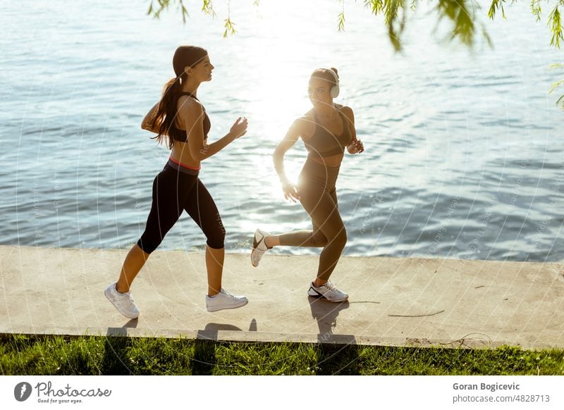 Junge Frau beim Lauftraining an der Flusspromenade Aktion aktiv Aktivität Erwachsener Athlet sportlich schön Kaukasier Großstadt Übung trainiert. passen Fitness