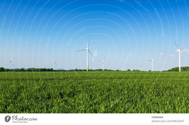 Windräder auf einem Feld Windkraftanlage Windpark vor blauem Himmel Landwirtschaft Ackerbau alternativ Alternative Energie Biostrom billiger Strom Klimawandel