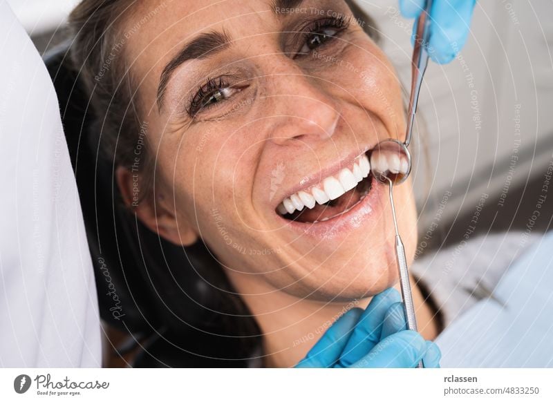 Zahnärztin untersucht die Zähne einer Patientin in der Zahnarztpraxis. dental Zahnmedizin Pflege Gesundheit Lächeln weiße Zähne Arzt geduldig Spiegel