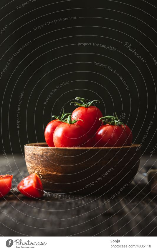 Frische Cocktailtomaten in einer Holzschüssel.Schwarzer Hintergrund. rot Schüssel Gemüse frisch Tomate Farbfoto moody Bioprodukte Vegetarische Ernährung