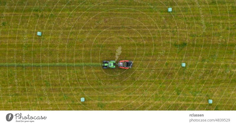 Luftaufnahme eines Traktors beim Mähen einer grünen Wiese im Sommer. Drohne Schuss Bauernhof oben Antenne landwirtschaftlich Ackerbau Agronomie Hintergrund