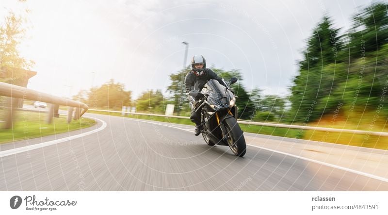 Motorrad auf der Straße in einer Kurve fahrend mit Bewegungsgeschwindigkeit auf einer Motorradtour. copyspace für Ihren individuellen Text. Fahrrad Spaß Jacke