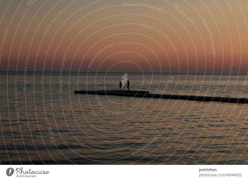 Zwei Menschen stehen bei Sonnenuntergang auf einem Steg am Meer. meer steg Paar romantik Kroatien Küste Himmel Ferien & Urlaub & Reisen Außenaufnahme Wasser