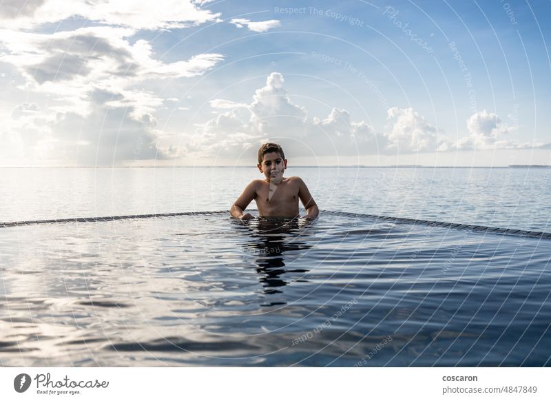 Kleines Kind schwimmt im Pool einer Hotelanlage aktive Menschen allein Strand blau Junge Kaukasier heiter Kindheit niedlich Spaß Fröhlichkeit Glück Spaß haben