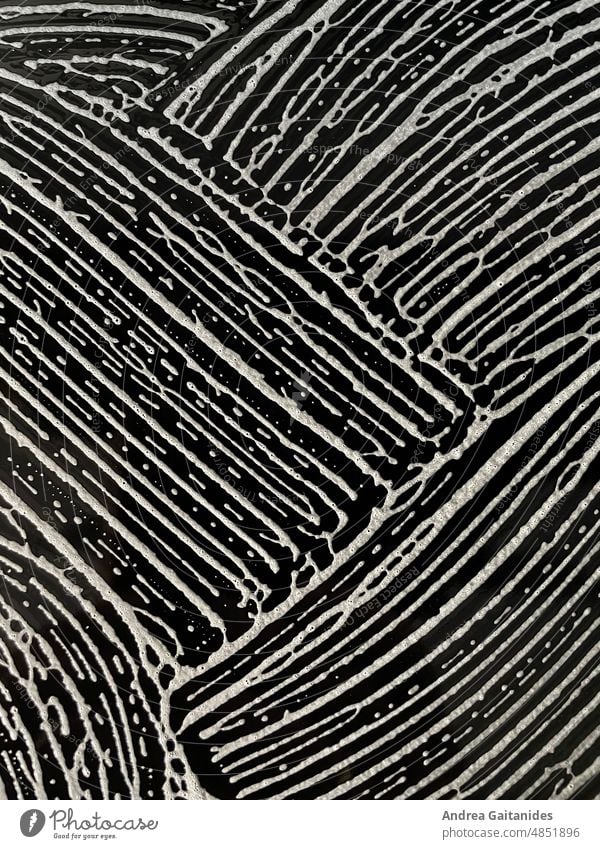 Muster aus weißem Schaum auf schwarzem Hintergrund, vertikal Strichmuster schwarz-weiß Struktur Bläschen Makro Detail Wischen Putzen wische putze