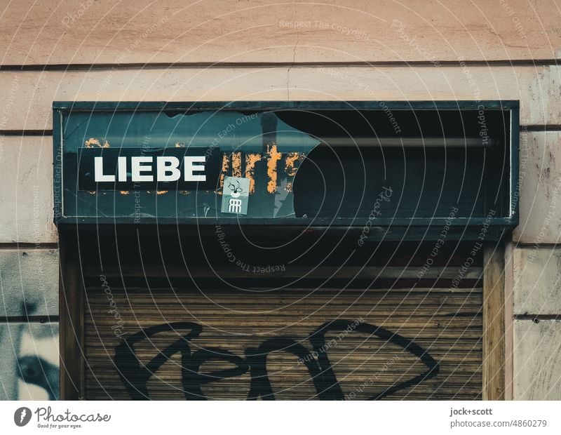 Liebe ist das, was übrig bleibt Wort Typographie Deutsch Hintergrund neutral Straßenkunst Großbuchstabe Zahn der Zeit Leuchtkasten Rollladen Ladengeschäft