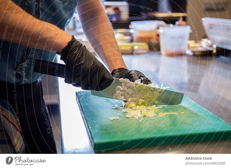 Koch hackt Gemüse mit Messer auf Schneidebrett Küchenchef zerkleinernd wirtschaftlich Porree Holzplatte Essen zubereiten vorbereitend Lebensmittel Restaurant