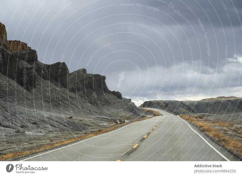 Landschaftlich reizvoller Berg zwischen asphaltierten Autobahnen Klippen Utah Nationalpark Straße Asphalt Fahrbahn wolkig reisen Spitzkuppe felsiger Aufschluss