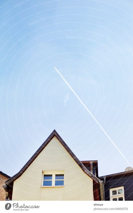 Kondensstreifen über dem Giebel eines kleinen Wohnhauses / Überflieger / Gedankenflug Hausgiebel Fenster wohnen Wohneigentum Himmel himmelblau fliegen