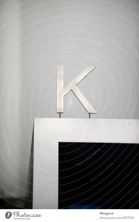 K-Frage Haus Fassade Zeichen Schriftzeichen Schilder & Markierungen Hinweisschild Warnschild hängen grau schwarz silber Ferne Buchstaben Eingang Kanzler