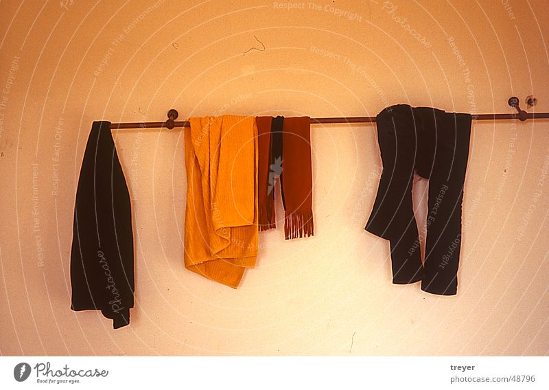 Kleider auf Kleiderstange Kleiderständer Bekleidung Wand Hose Schal Hemd Handtuch Stab gelb rot braun schwarz weiß orange