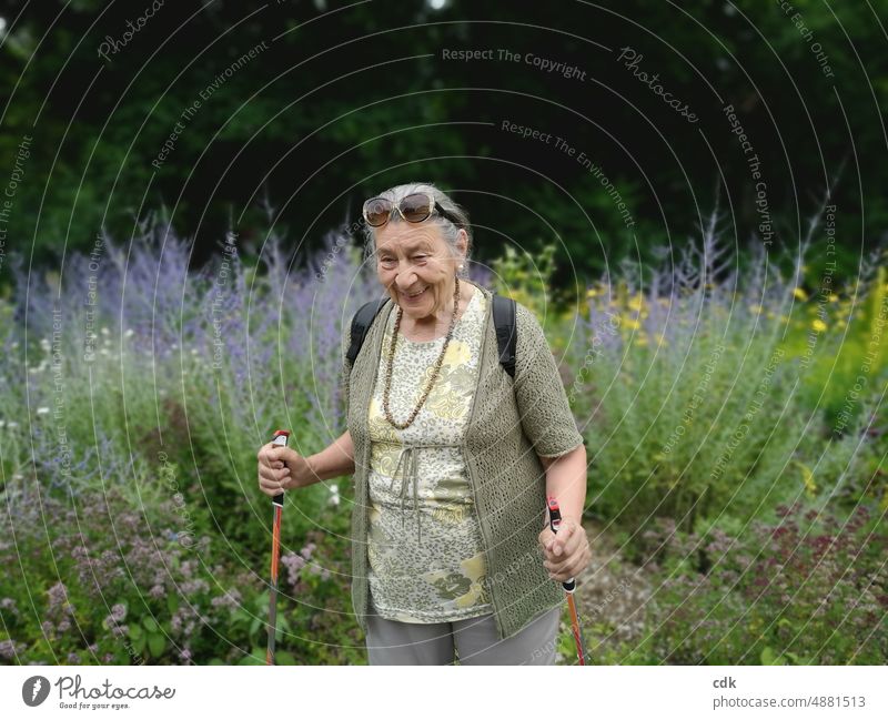 Sommerspaziergang | vergnügte Seniorin | zwischen blühenden Kräutern unterwegs. Frau Dame Großmutter 80+ Mensch Porträt Ruhestand Gesundheit Zufriedenheit Glück
