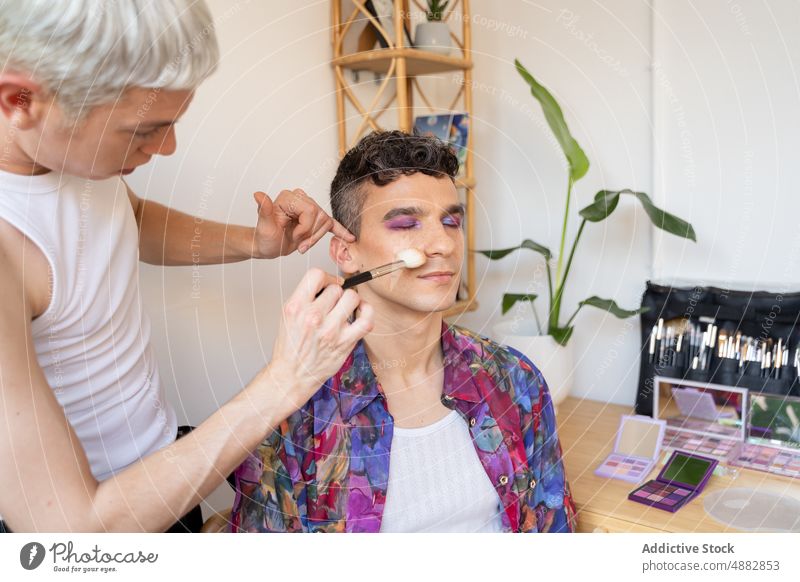 Transgender-Mann wird mit Make-up-Pinsel errötet erröten Bürste Nahaufnahme Gesicht Lidschatten Paar anwendend Künstler Kosmetik schwul Freund Mode Lifestyle