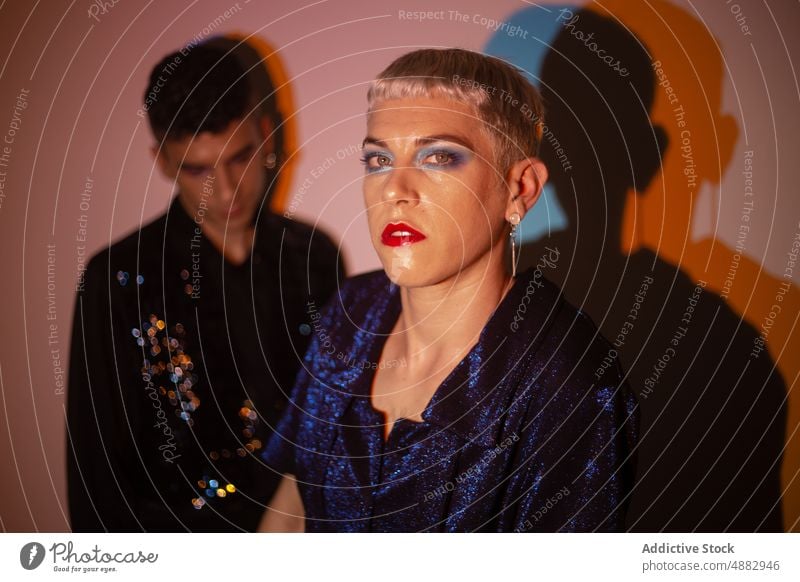 Junger Transgender-Mann trägt Make-up im Studio schwul queer Mode Individualität lgbtqi Stolz beleuchtet Studioaufnahme feminin Hintergrund Schönheit jung