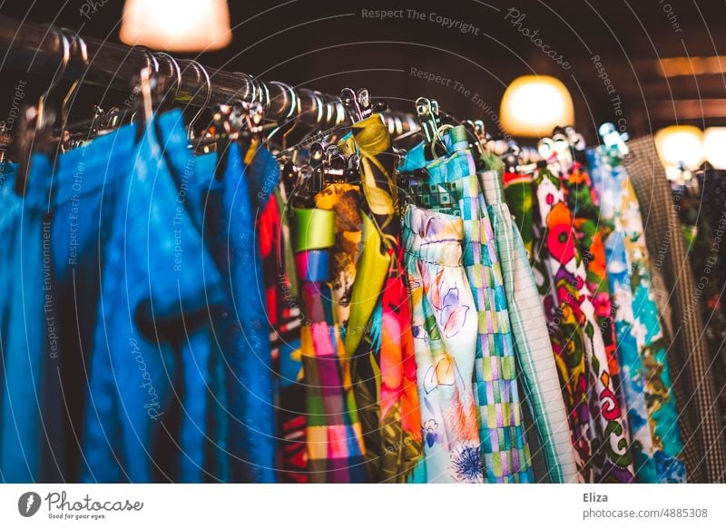 Bunte Kleidung an einer Kleiderstange in einem Second Hand Geschäft oder auf dem Flohmarkt Second hand nachhaltig bunt Second-Hand Laden Mode Bekleidung