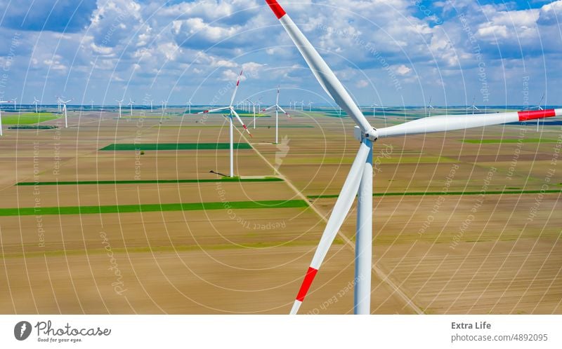 Luftaufnahme mehrerer Windmühlen, Windgeneratoren und Turbinen, die durch Umwandlung von Bewegungsenergie erneuerbare und saubere Energie erzeugen oben