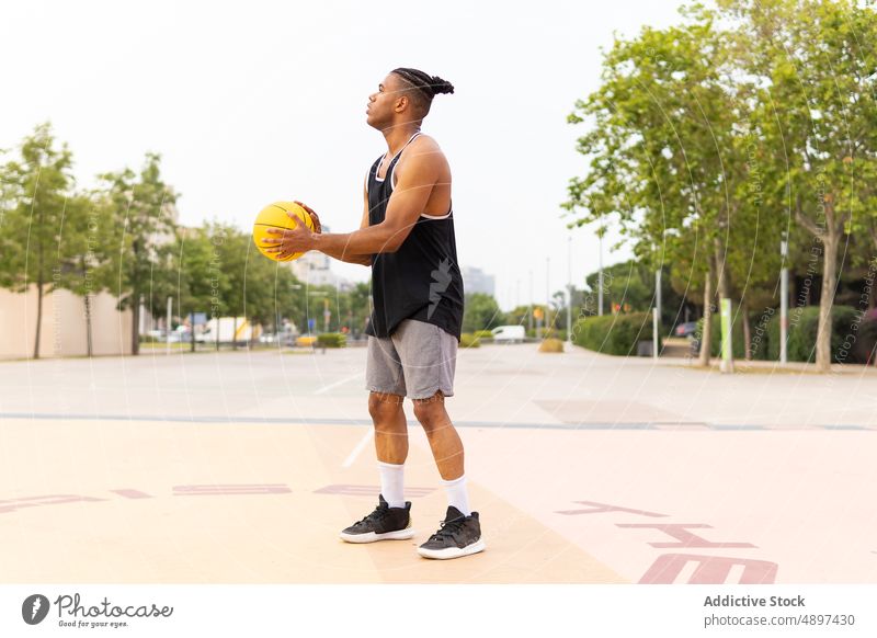 Spanischer Sportler prellt Basketball spielen hüpfen Ball Park Training Sportpark Aktivität Energie männlich ethnisch hispanisch tagsüber Frisur Zopf Athlet