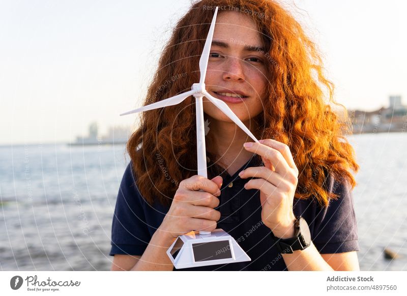 Frau hält Windmühlenmodell hoch Model Teil von regenerativ MEER Überfall Staumauer Ökologie Großstadt Himmel recycelbar Miniatur Elektrizität