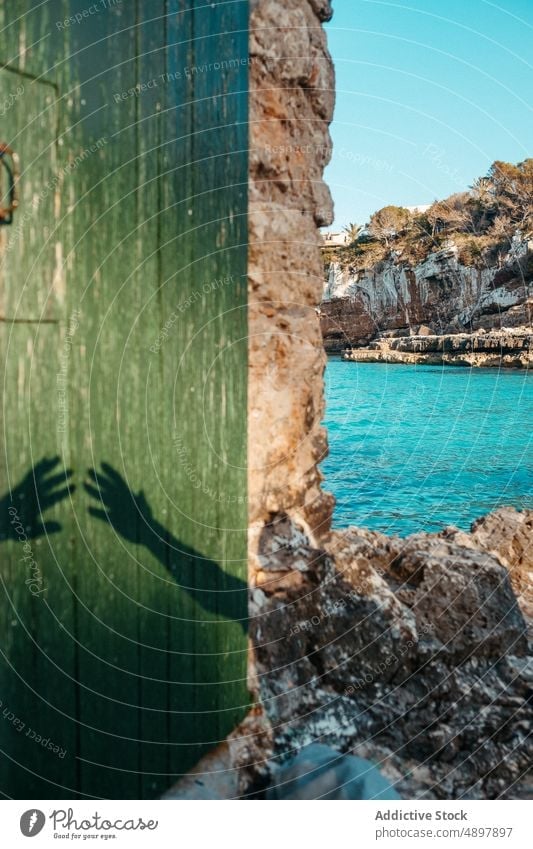 Hände Schatten auf gealterten Tür der Steinhaus auf felsigen Strand im Sonnenlicht Haus Hand sich[Akk] melden MEER Feiertag Paar Meeresufer Sommer Urlaub