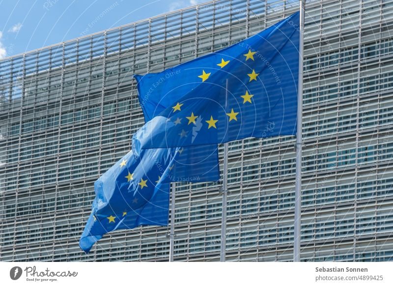 Drei wehende EU-Flaggen vor dem Gebäude der Kommission der Europäischen Union in Brüssel, Belgien Symbol Politik Rat international Gesetzgebung politisch blau