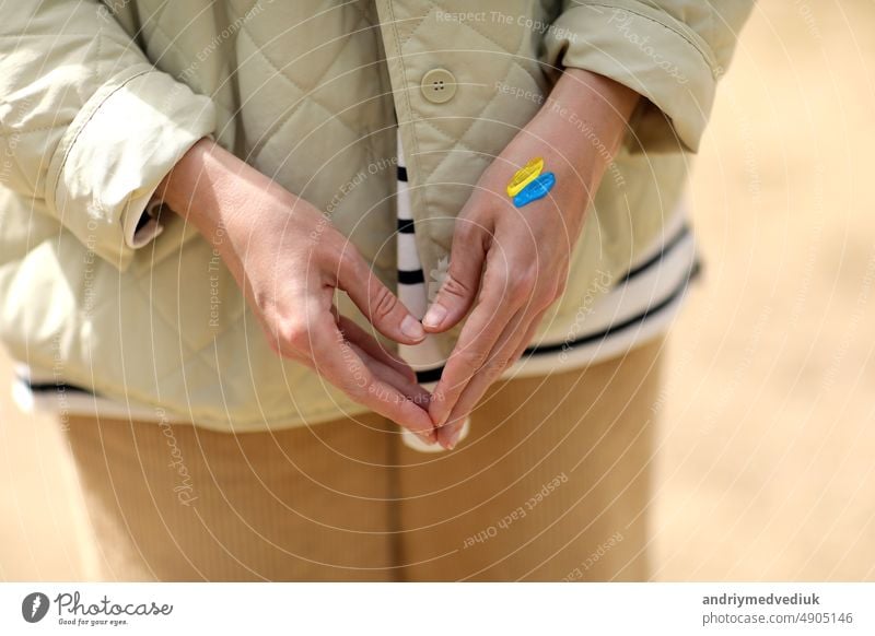 Stoppt den Krieg. Frieden in der Ukraine. Frau mit Bild der ukrainischen Flagge auf der Hand. Antikriegsunterstützungskonzept. Hohe Qualität Foto. Konflikt