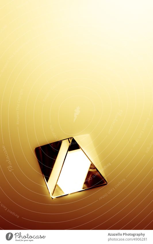 Abstraktes Bild einer Kristallpyramide mit goldgelben Strahlen aus hellem Licht. 3d abstrakt Unschärfe verschwommen Konzept konzeptionell Kondenswasser