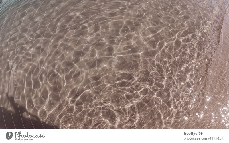 Plätschern auf dem Wasser gegen Sand kräuselt Strand Lichteffekt Textfreiraum Wellen Textur Sauberkeit Marin Feiertag Natur Urlaub ruhig schwimmen Hintergrund