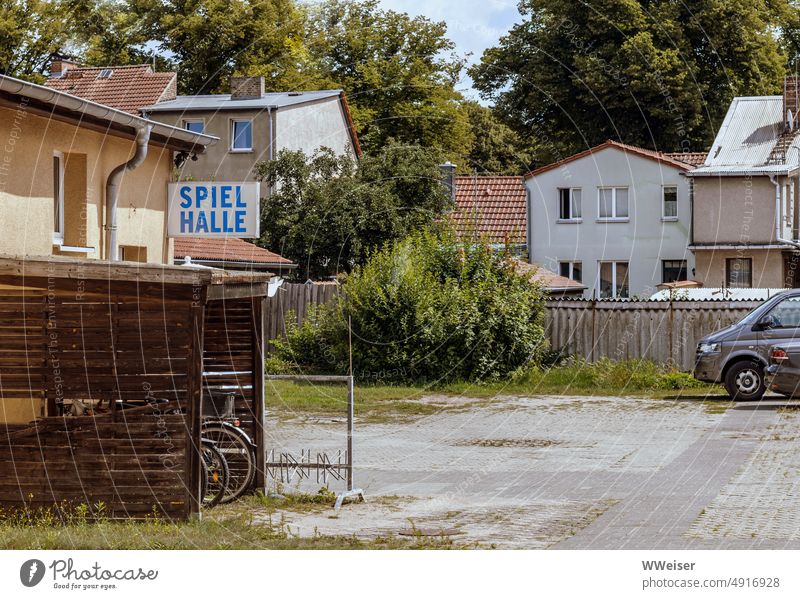 Auf dem Hinterhof eines kleinstädtischen Wohnblocks befindet sich eine Spielhalle Hof Schild ausgeschildert Hinweis Eingang versteckt verborgen Wohnhäuser