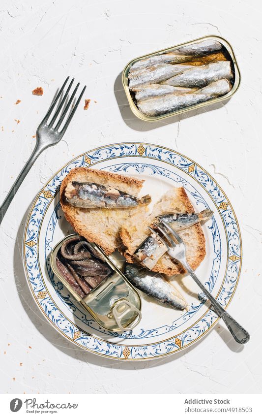 Nahaufnahme eines Brottellers mit Sardinen Metall Büchse Dose konservieren offen metallisch Draufsicht Lebensmittel Meeresfrüchte Fisch konserviert Ernährung