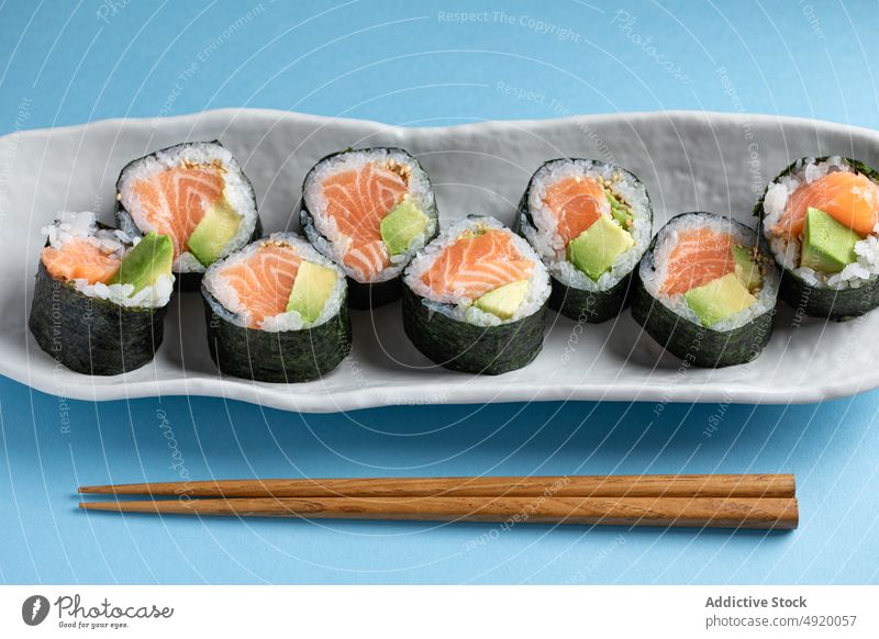 Leckere Futomaki-Norwegerollen mit Lachs Japanisch Sushi futomaki Kulisse Avocado Meeresfrüchte Fisch traditionell Essstäbchen Kultur Speise Lebensmittel Reis