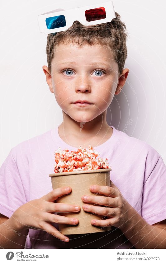 Staunender Junge mit 3D-Brille und Popcorn Kind 3d Popkorn Snack Vergnügen Erstaunen Film Schock Leckerbissen wow Licht Eimer starren erstaunt verblüfft Hobby