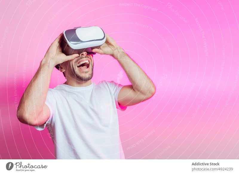Fröhlicher Mann mit VR-Brille, der seinen Erfolg feiert Virtuelle Realität Cyberspace futuristisch Hochtechnologie Sieg gewinnen feiern Spieler modern erreichen