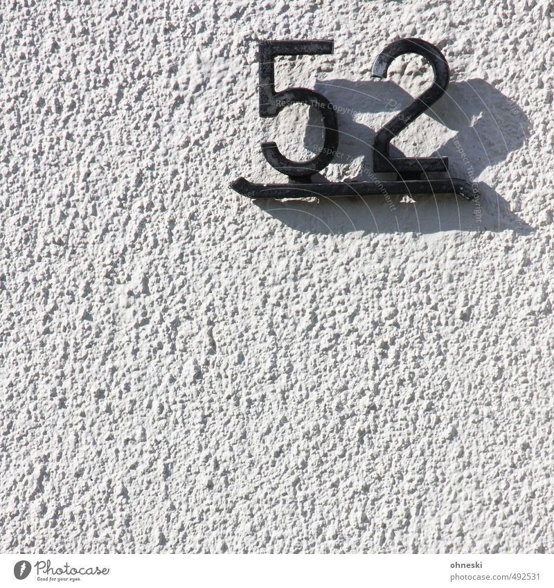 Hausnummer Mauer Wand Fassade Ziffern & Zahlen schwarz weiß Häusliches Leben Farbfoto Gedeckte Farben Außenaufnahme Strukturen & Formen Textfreiraum unten