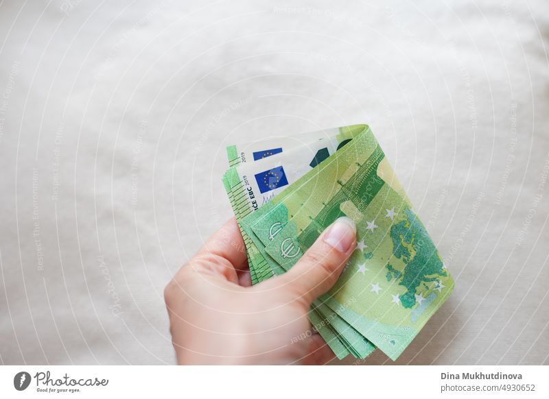 Hand hält ein Bündel grüner 100-Euro-Banknoten in Großaufnahme. Inflation in der Europäischen Union Konzept. Geld auf weißer Oberfläche isoliert. Stapel von hundert Euro-Noten. Barzahlungen Konzept.