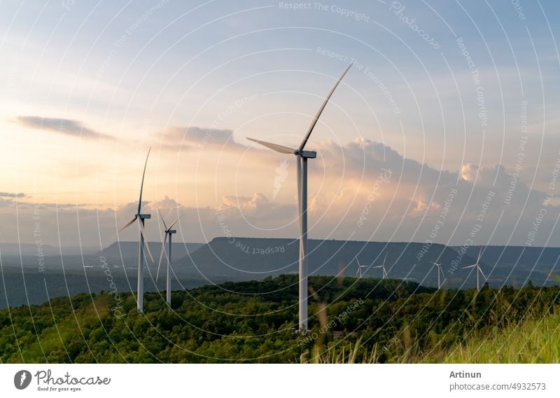 Windenergie. Windkraft. Nachhaltige, erneuerbare Energie. Windturbinen erzeugen Strom. Windmühlenpark auf einem Berg mit Sonnenuntergang am Himmel. Grüne Technologie. Erneuerbare Ressource. Nachhaltige Entwicklung.