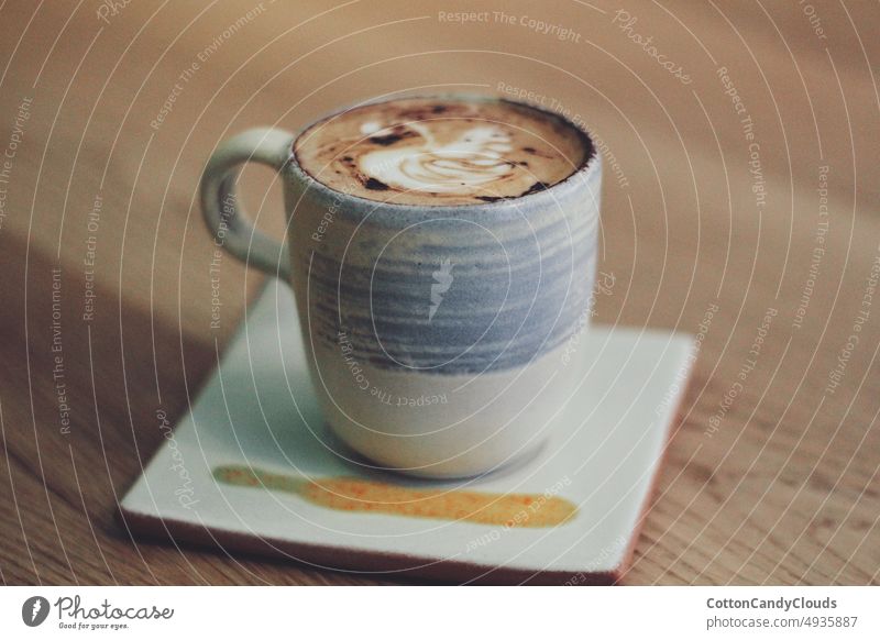 Eine Tasse Cappuccino in einer Kaffeebar Café Espresso Getränk Kaffeehaus Kaffeetasse Frühstück heiß Becher Hintergrund frisch hölzern weiß braun vereinzelt