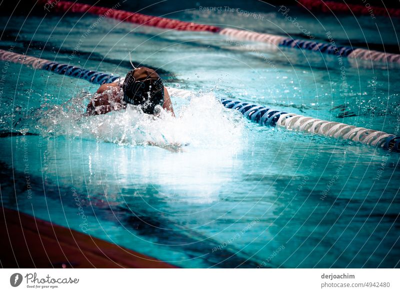 Ein Mädchen beim Sportschwimmen . Den Kopf halb  im aufspritzenden Wasser versucht sie mit kräftigen Zügen an das Ziel zu kommen. Schwimmen & Baden Schwimmsport