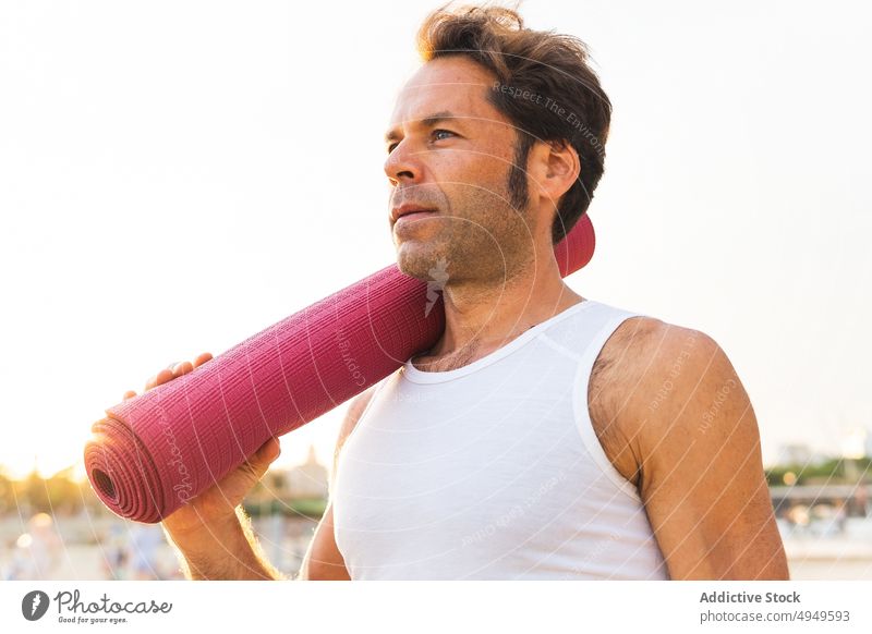 Älterer Mann mit Matte auf der Schulter Unterlage Strand Yoga Sonnenaufgang Morgen rollen Sitzung führen Windstille männlich Lebensmitte reif Pause Sommer MEER