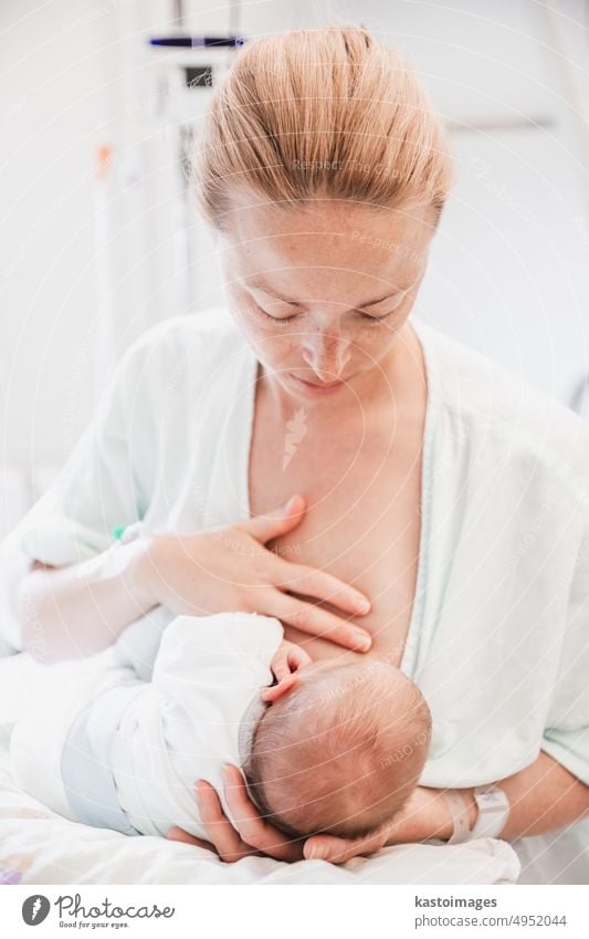 Eine frischgebackene Mutter stillt ihr neugeborenes Kind im Krankenhaus einen Tag nach der Geburt sorgfältig Brust stillen Baby Säugling Junge Gesundheit jung