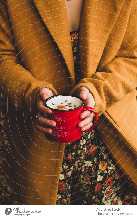 Frau mit Emailleschale mit leckerem Getränk im Garten Becher trinken warm Picknick Hand Erfrischung Kaffee Mantel Lebensmittel Latte Tasse Gesundheit essbar